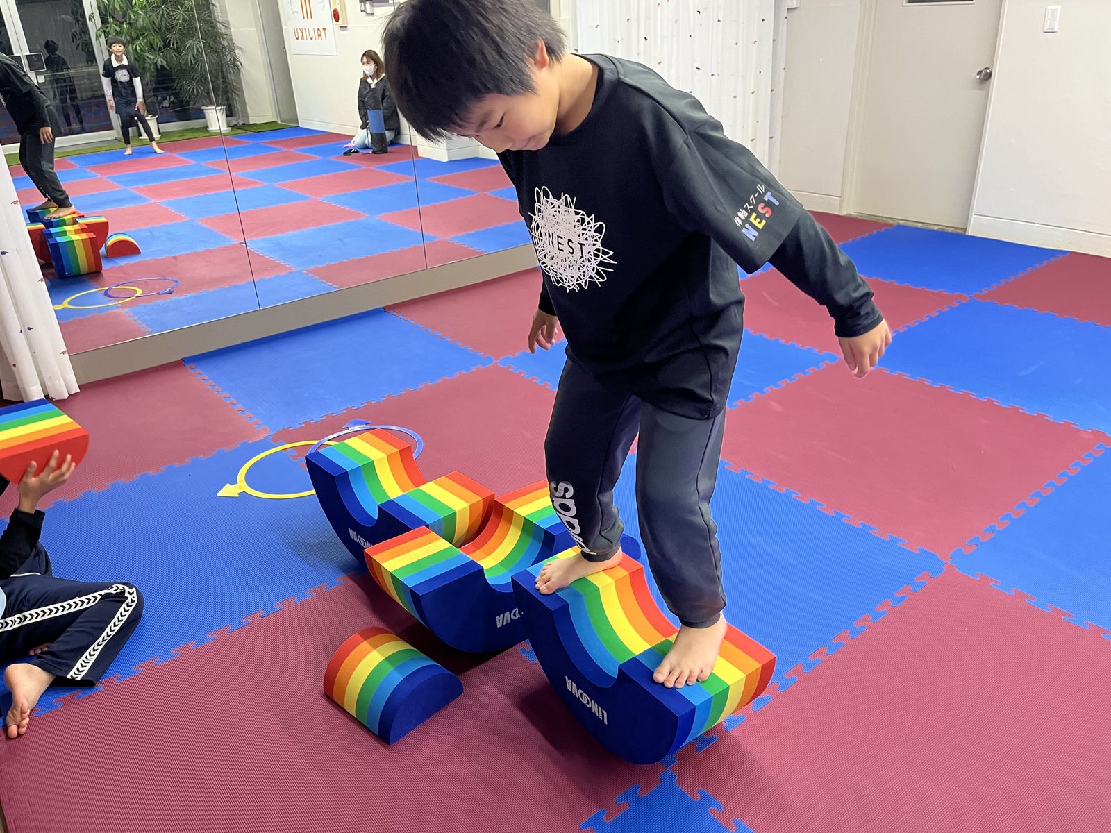 ココレインボーの上でバランスをとる子どもの様子